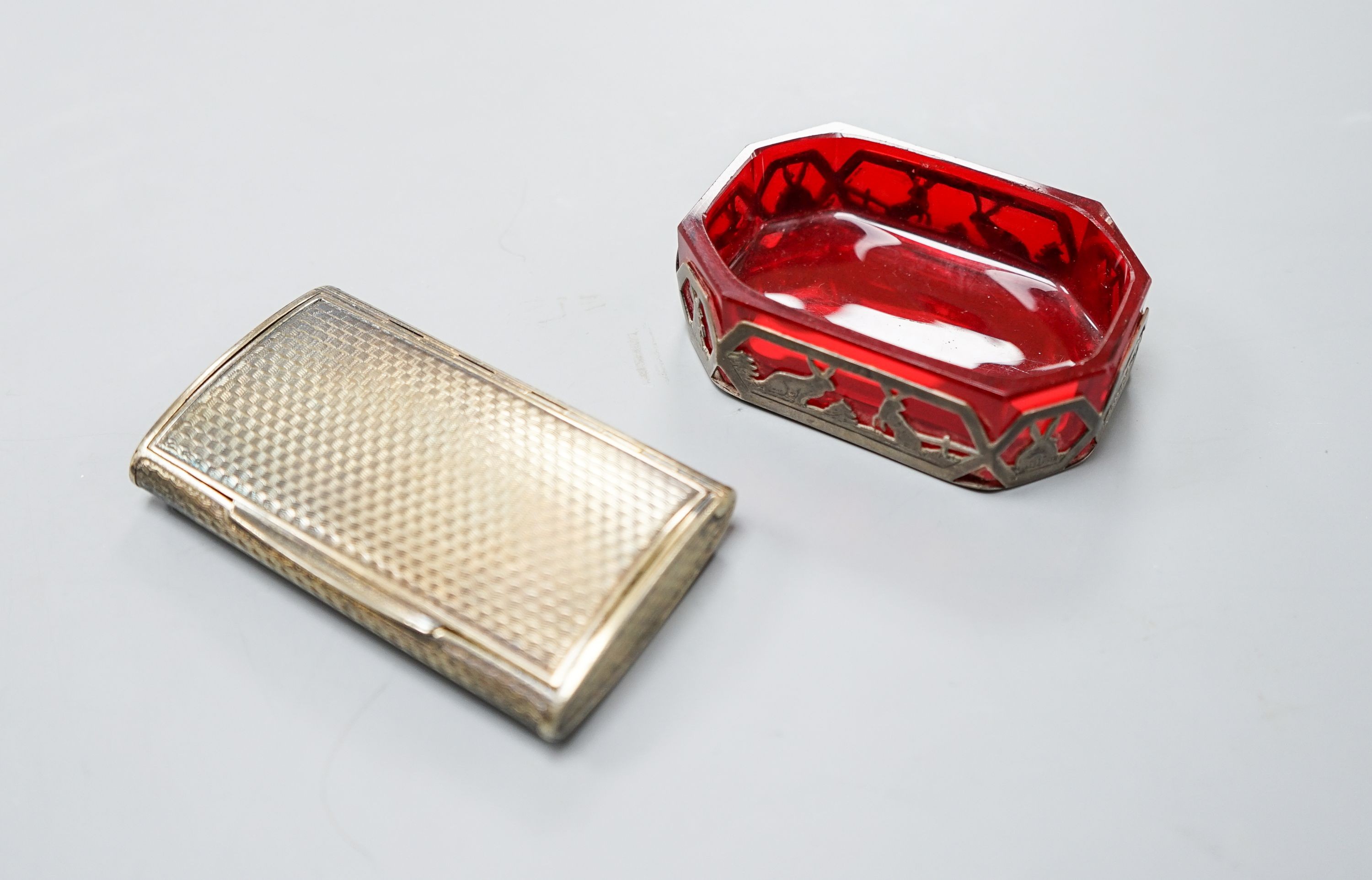 An early 20th century Austro Hungarian gilt white metal snuff box, 82mm and a similar later mounted ruby glass dish, 72mm.